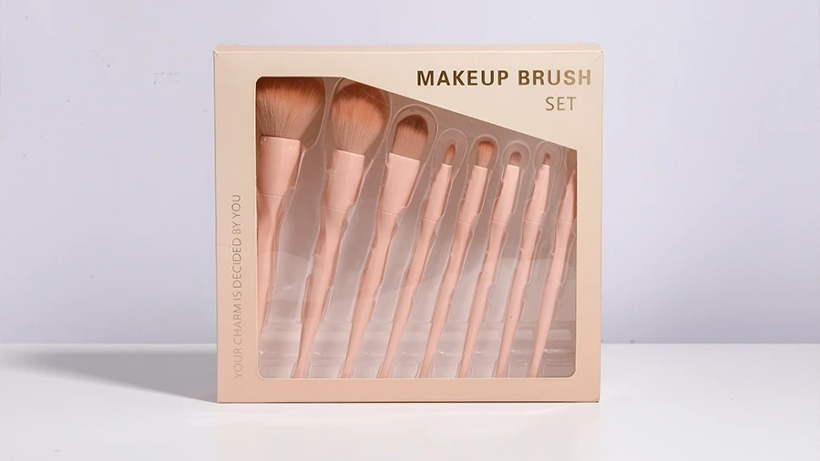 Pink paper box makeup brush packaging with a clear window display showing a multi-piece brush set.