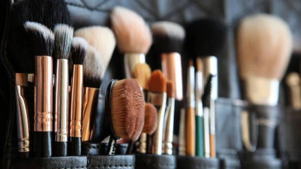Professional makeup brush set organized in a black leather pouch, 粉末を含む, 輪郭, and eye brushes.